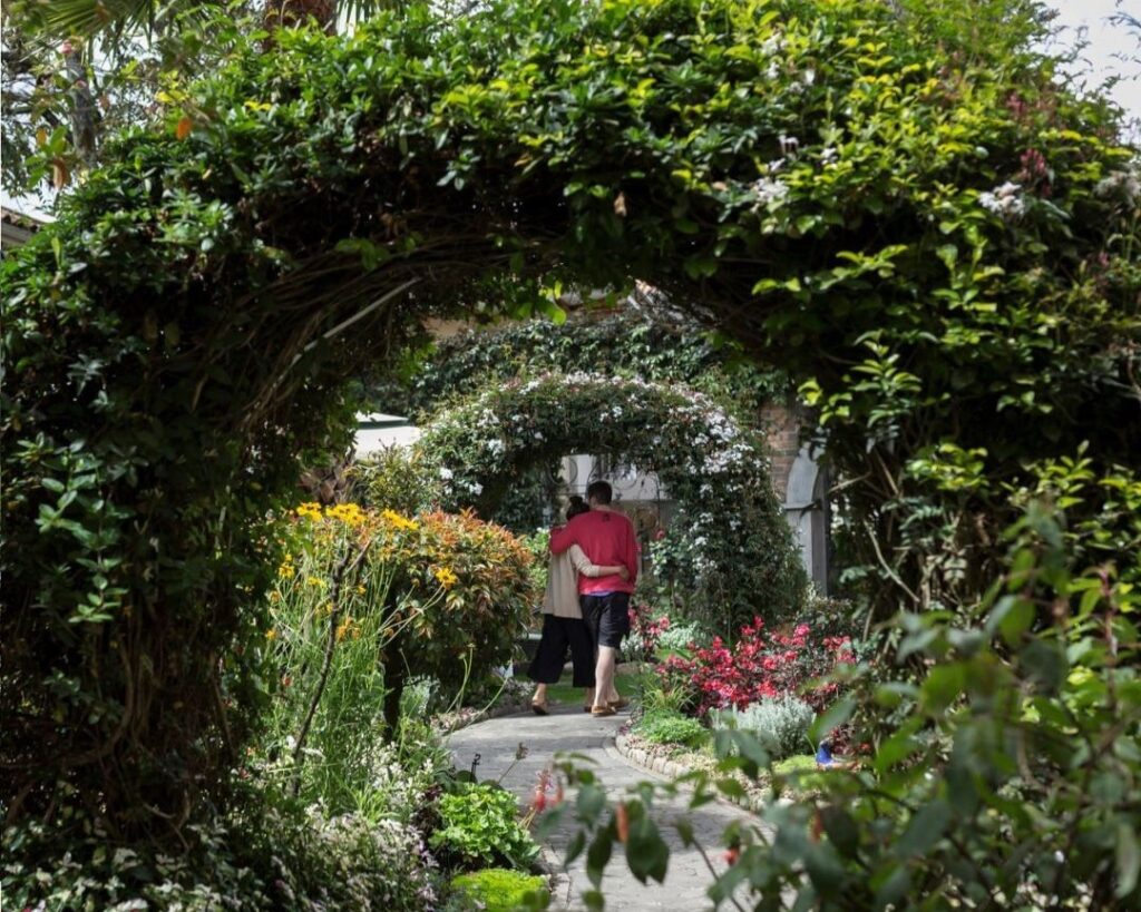 A couple is huging in the mansion alcazar gardens